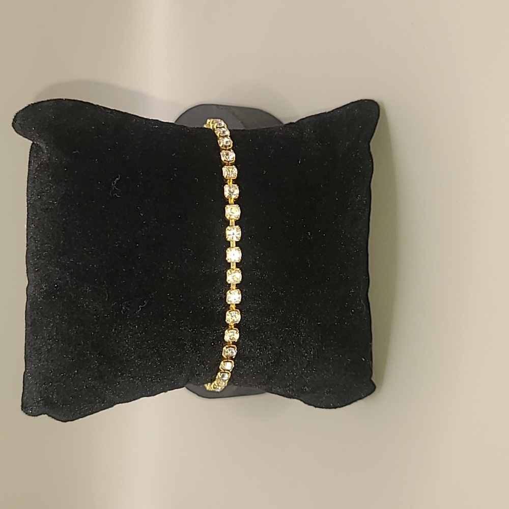 Gold tone tennis bracelet with faux diamonds